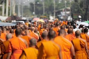 un grupo de monjes en peregrinación caminan por la calle al mediodía, tailandia. foto