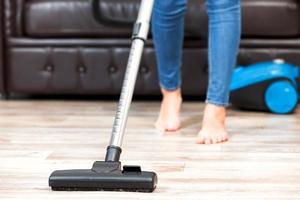 Young woman vacuum cleaning the apartment, housework photo