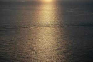 Close up to the texture of the sea surface with the abstract golden colour background in the twilight time. photo