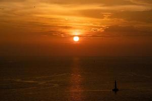 Sunset on the sea and through the clouds over. Tranquil seascape with the horizonal skyline. photo