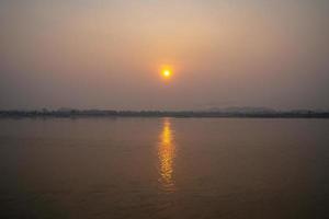 The Sunrise environment at Mekong River, shoot image from Thailand side to Laos country with sunlight reflexion on surface river. photo