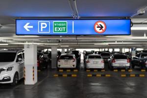 Signage Lightingbox in the indoor carparking, tell driver which way is parking lot or exit. Thai Language in green square on lightinbox means EXIT. photo