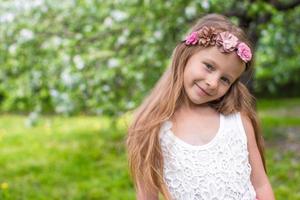 Portrait of little adorable girl in blossoming apple garden photo