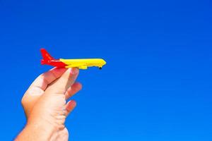 Small plane in hands on background of blue sky photo