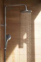 Outdoor shower head for the bath and showering cold water to body before jumping in the resort pool. photo