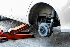 close up to the Fixing of broken tire with white car in Thailand local garage. photo
