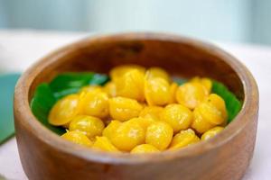 ThongYod Golden Drop Traditional Thai Desserts on banana leaf in wood bowl. photo