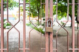 close up to the lock, hangs on to brown steel door at outdoor field. photo