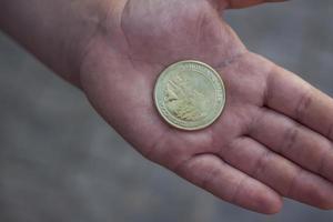 2022-08-16 rusia, samara, centro turístico castillo garibaldi en el pueblo de khryashchevka, región de samara. moneda conmemorativa recién acuñada en la mano foto