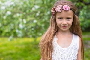 retrato de una niña adorable en un floreciente jardín de manzanas foto