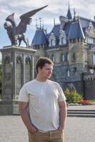 A man on the background of a Gothic-style castle. The territory of the tourist complex photo