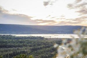 puesta de sol en el río volga. paisaje natural. reflejo, cielo azul y luz solar amarilla. paisaje durante la puesta de sol. foto