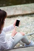 Woman with cellphone outdoors on the street. Tourist using mobile smartphone. photo