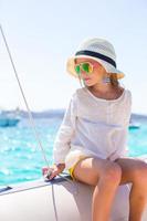 Little girl enjoying sailing on boat in the open sea photo