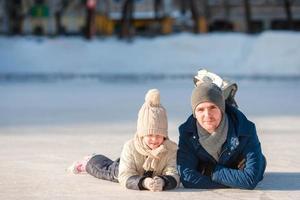 retrato de niña adorable y padre joven patinando foto