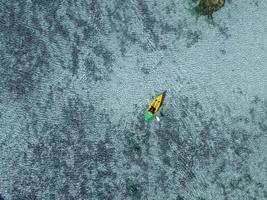 paddling in polynesia blue lagoon aerial drone photo