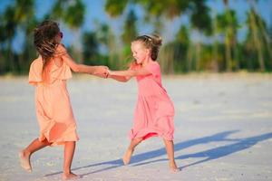 Adorable little caucasian girls at beach during summer vacation. Happy kids having fun together on their family summer vacation. photo