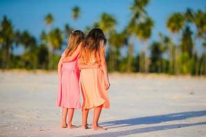 niñas caucásicas en la playa durante las vacaciones de verano. niños felices divirtiéndose juntos en sus vacaciones familiares de verano. foto