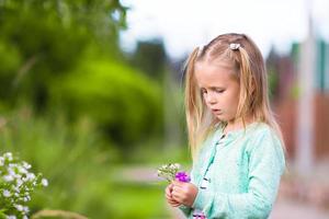 Little adorable girl in summer park outdoors photo