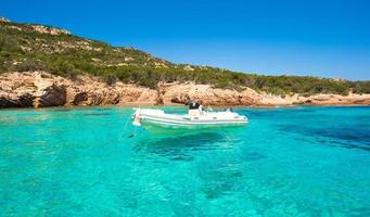 Small boat in turquoise clear sea photo