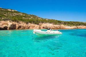 Small boat in turquoise clear sea photo