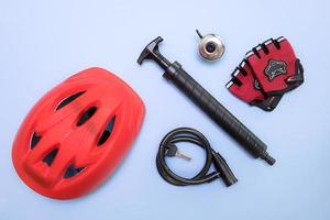 cyclist's accessories on a blue background - helmet, pump, lock with keys, bell, gloves