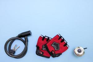 cycling gloves, padlock and bell on a blue background with copy space photo