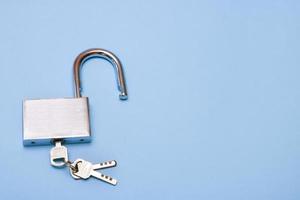 open padlock padlock with keys on blue background with copy space photo