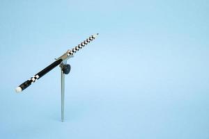 compass with a pencil raised up on a blue background with copy space photo