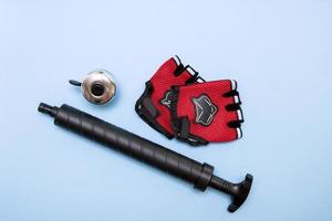 bicycle accessories - gloves, pump, bell, on a blue background photo