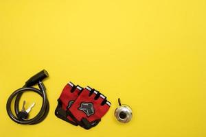 bicycle lock, gloves and a bell on a yellow background with copy space photo