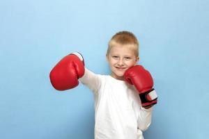 funny blond boy in red boxing gloves depicts a boxer photo