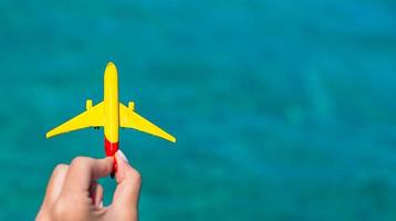 Small homemade plane in female hand on background of the sea photo