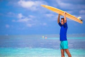 Happy young man surfing on the tropical coast photo