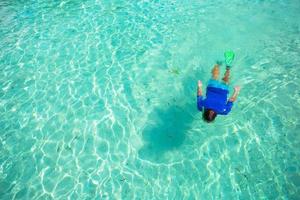 Young man snorkeling in clear tropical turquoise waters photo