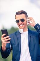 Man is reading text message on mobile phone while walking in the park photo