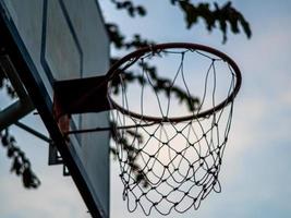 un viejo aro de baloncesto al aire libre y una red cuando nadie juega foto