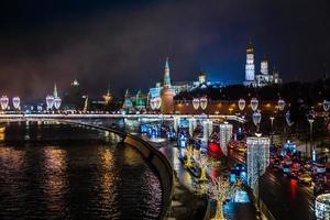 Night view to Moscow Kremlin and river banks decorated with NY ilumination with road full of traffic in the foreground, Moscow, Russia photo