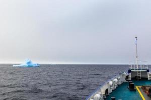 Ship bow and Iceberg drifting at Lemaire Channel, Antarctica