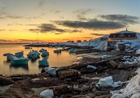 vista de la puesta de sol del puerto viejo de la ciudad de nuuk con icebergs, groenlandia
