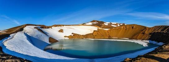 Viti volcanic crater lake green surface with snow and blue sky panorama, Myvatn lake surroundings, North Iceland photo