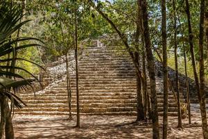 Small ancient pyramid of old Mayan civilization city hidden in the forest,  Coba archeological site, Coba, Yucatan, Mexico photo