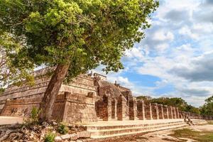Group of thousand columns complex and tree in foreground, Chichen Itza archaeological site, Yucatan, Mexico photo