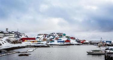 puerto con barcos y coloridas casas inuit en las rocas en backgr