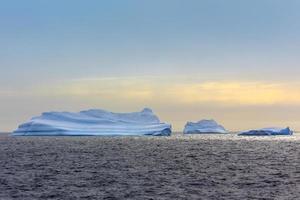 Three huge blue icebergs drifting across the sea in the middle of nowhere, Antarctica photo