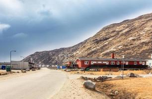 Street in Kangerlussuaq settlement with small living houses among mountains, Greenland photo