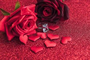 Will you marry me. Wedding ring red scarlet roses and many red hearts on red glitter background. Engagement marriage proposal wedding concept. St. Valentine's Day postcard. Banner on valentines day. photo