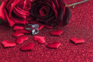 Will you marry me. Wedding ring red scarlet roses and many red hearts on red glitter background. Engagement marriage proposal wedding concept. St. Valentine's Day postcard. Banner on valentines day. photo