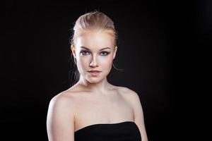 Beauty fashion model girl with long healthy smooth straight hair ponytail hairstyle on black background. Smiling pretty woman looking camera. Perfect Fresh Skin Portrait. Youth and Skin Care Concept. photo