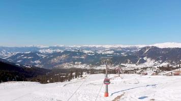 goderdzi, georgia, 2023 - vista panorámica estación de esquí de invierno goderdzi con teleférico opera en un día soleado con fondo del cáucaso y cielos despejados. video